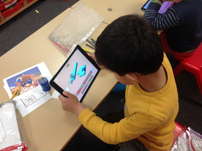 Boy playing Rodocodo coding game at school